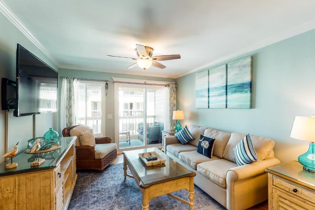 uma sala de estar com um sofá e uma televisão em Oceanside 212-C em Isle of Palms