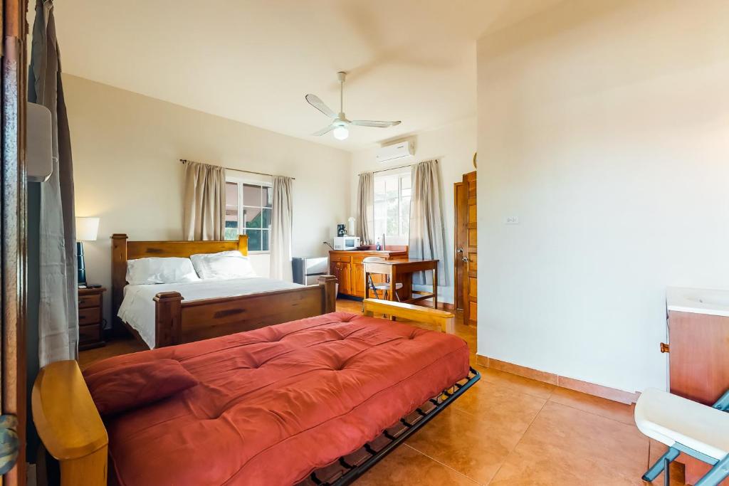 sypialnia z łóżkiem z pomarańczową kołdrą w obiekcie Isebei Guest House w mieście Hopkins