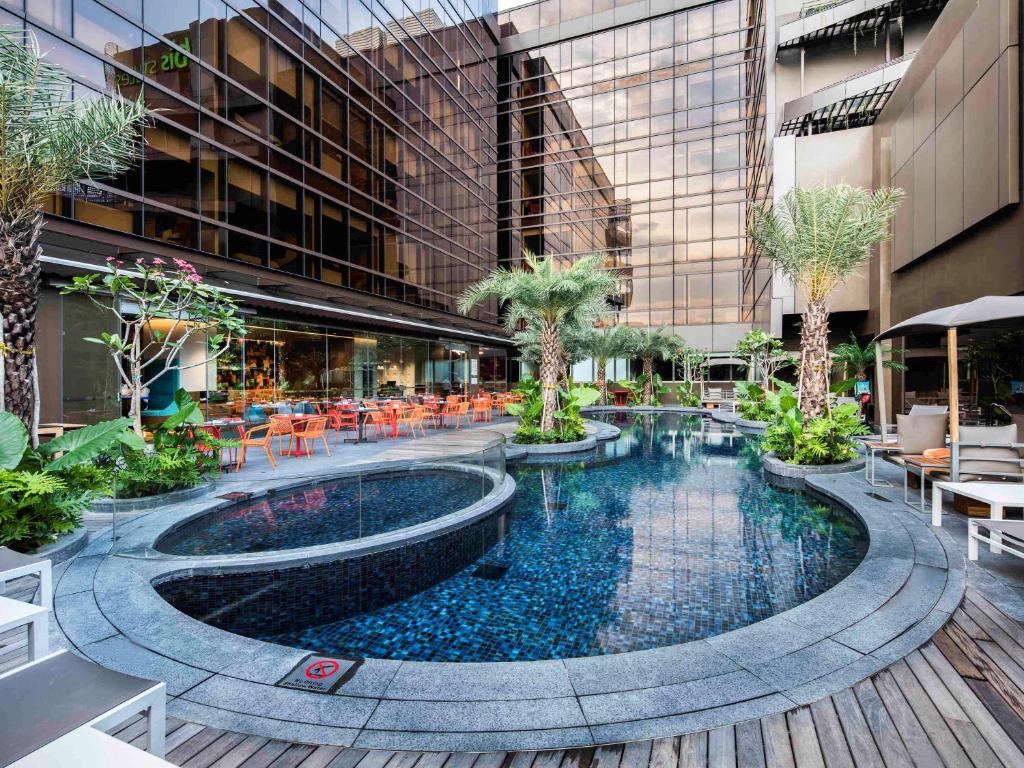 - une cour avec une piscine dans un bâtiment dans l'établissement Ibis Styles Singapore On Macpherson, à Singapour