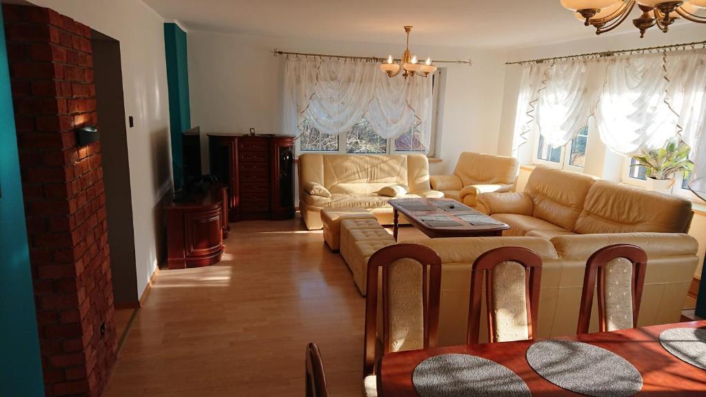a living room with a couch and a table at BASTÓWKA 2 Apartamenty in Ustroń