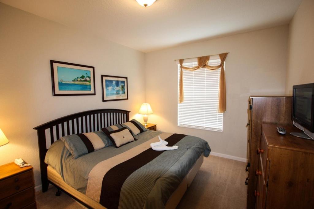 a bedroom with a large bed and a television at 4114 Viz Cay in Orlando