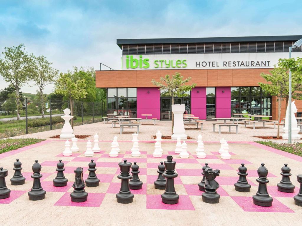ibis Styles Castres في كاستر: لوحة شطرنج عملاقة أمام مطعم الفندق المناديل