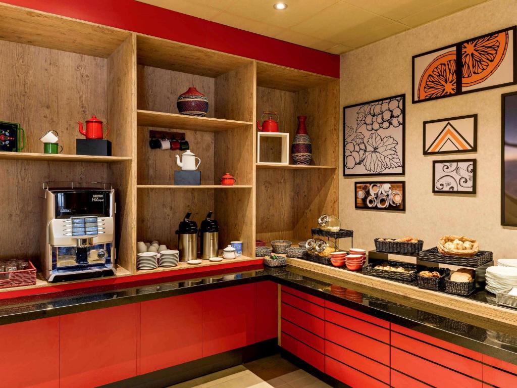a kitchen with red cabinets and a counter with a microwave at ibis Sao Bernardo do Campo in São Bernardo do Campo