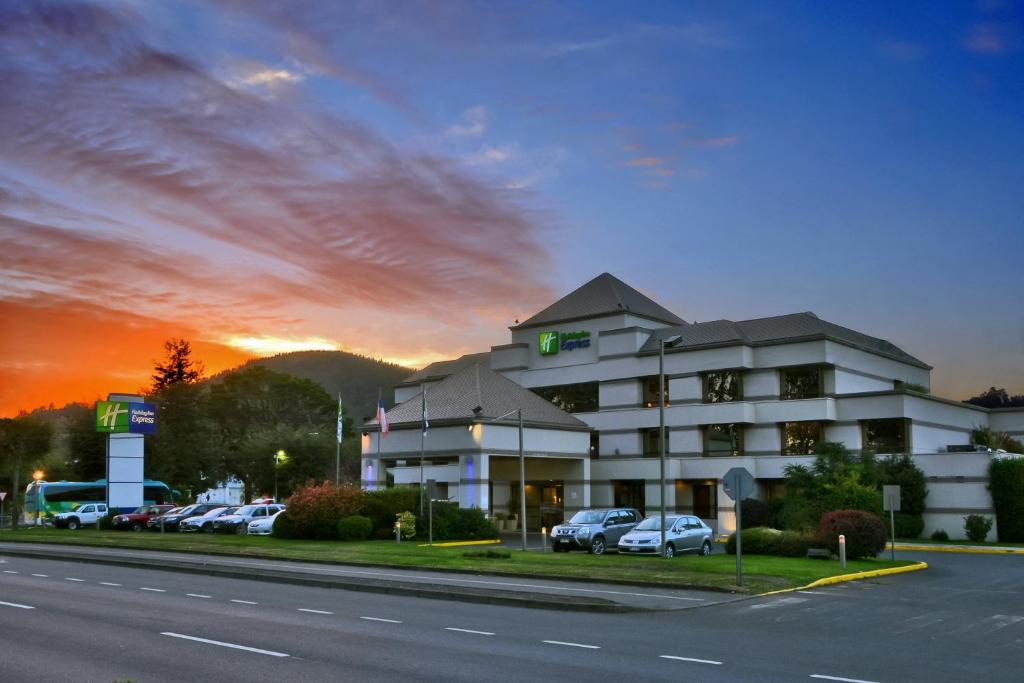 un hotel con coches estacionados en un estacionamiento en Holiday Inn Express - Temuco, an IHG Hotel, en Temuco