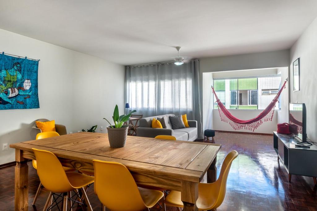 - un salon avec une table en bois et des chaises jaunes dans l'établissement Excelente 3 Quartos Rua Navegantes em Boa Viagem No melhor local da praia SAL802, à Récife