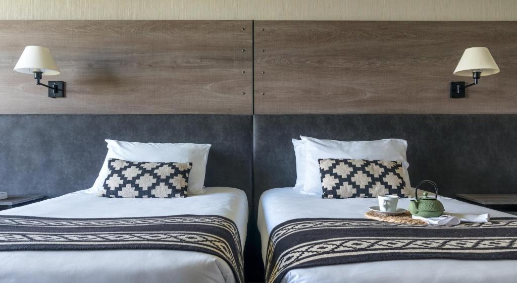 two beds sitting next to each other in a room at Río Serrano Hotel + Spa in Torres del Paine