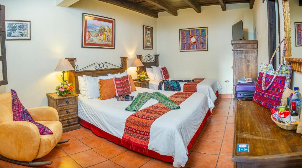 um quarto com uma cama e uma cadeira em Hotel Meson del Valle by AHS em Antigua Guatemala
