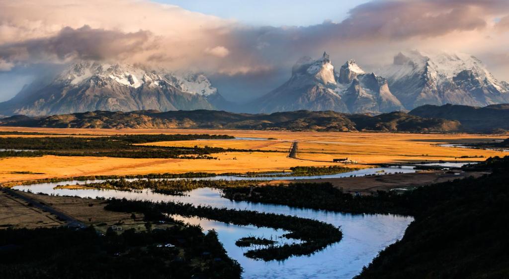 a view of a mountain range with a river at Río Serrano Hotel + Spa in Torres del Paine