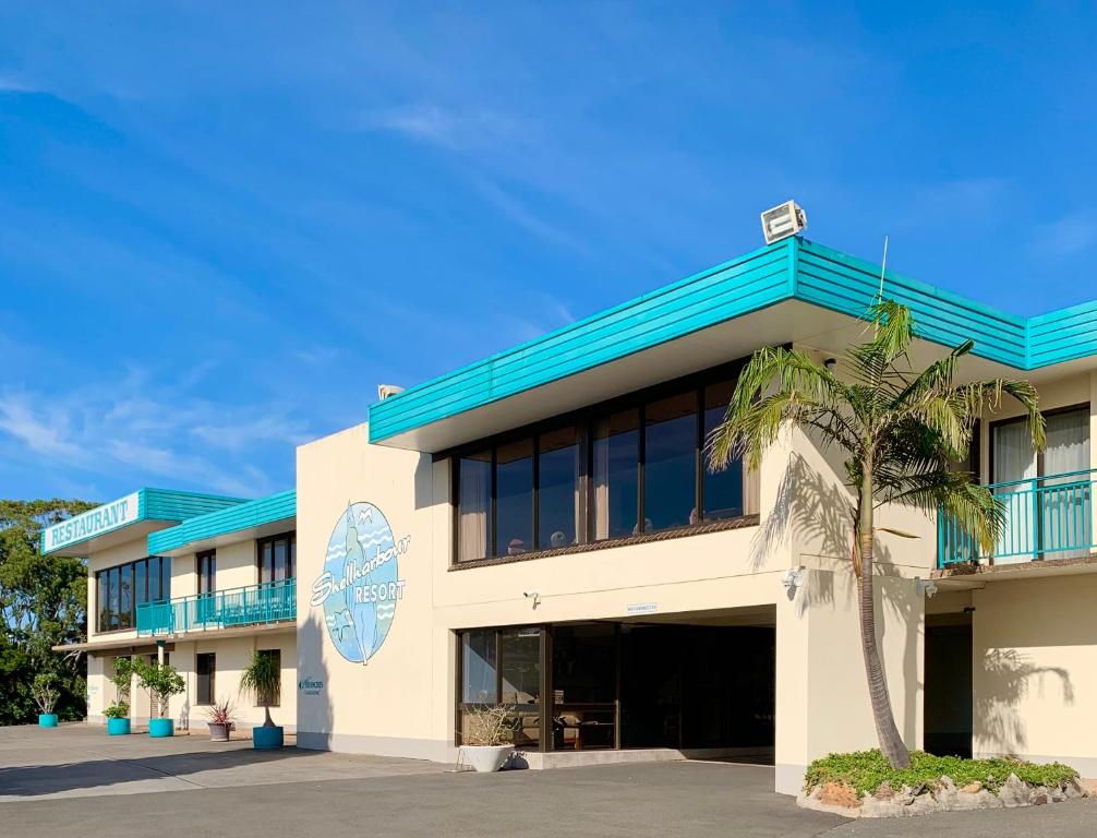 a building with a palm tree in front of it at Shellharbour Resort and Conference Centre in Shellharbour