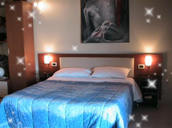 um quarto com uma cama grande e um cobertor azul em B&B Suite em Viagrande