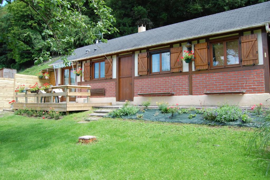 una casa de ladrillo rojo con un patio de hierba en le chalet de la vallée en Bouquelon