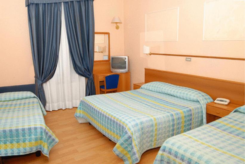 Łóżko lub łóżka w pokoju w obiekcie Hotel Porziuncola
