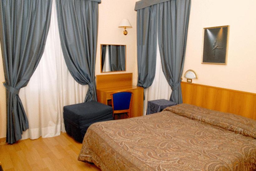 Łóżko lub łóżka w pokoju w obiekcie Hotel Porziuncola