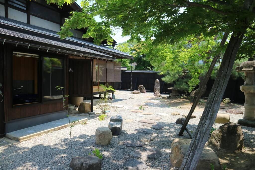un jardin en face d'un bâtiment avec des rochers dans l'établissement Yoshiki no Sato Dainichi no Yado, à Hida