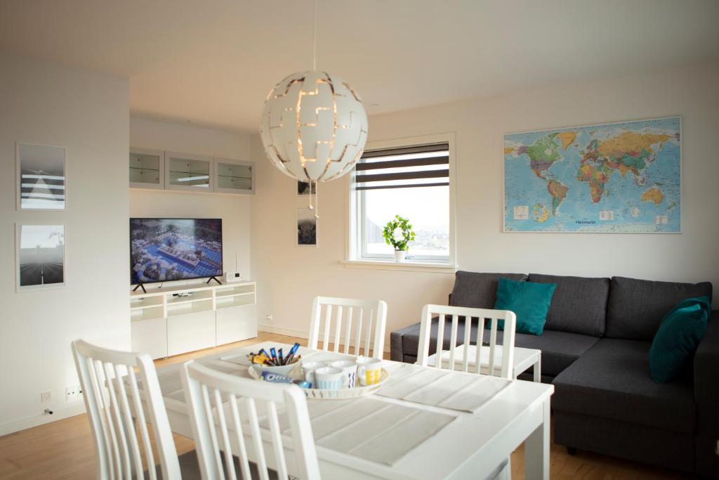 a living room with a table and chairs and a couch at Mørk Apartments- Great View in Tórshavn