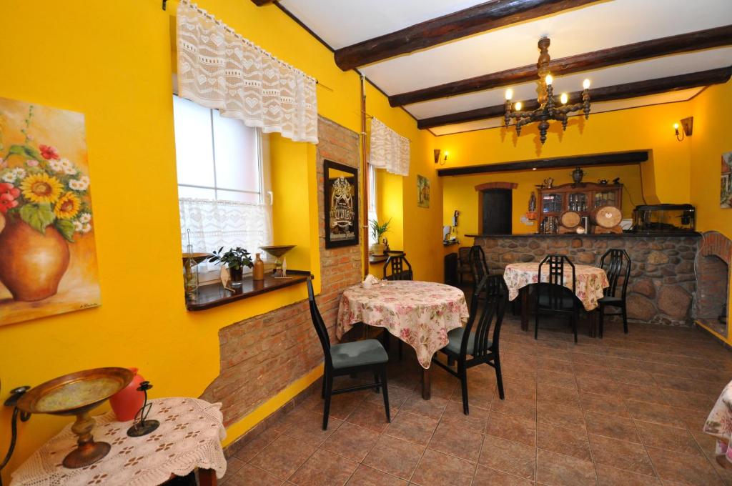 comedor con 2 mesas y paredes amarillas en Zajazd Wiejski, en Ozorzyce