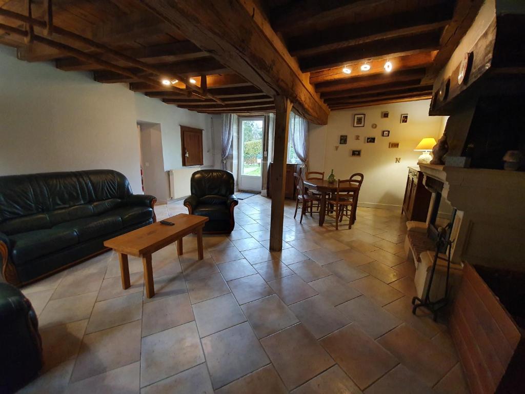 sala de estar con sofá y mesa en le coq du morvan, en Bussières