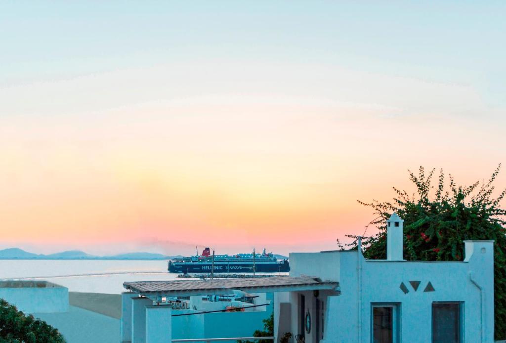um navio de cruzeiro na água ao pôr do sol em Castle Mansions em Naxos Chora