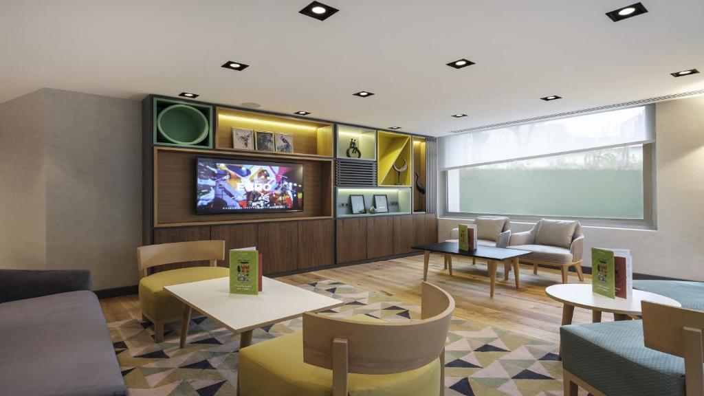 a waiting room with a tv and tables and chairs at Holiday Inn Istanbul Old City by IHG in Istanbul
