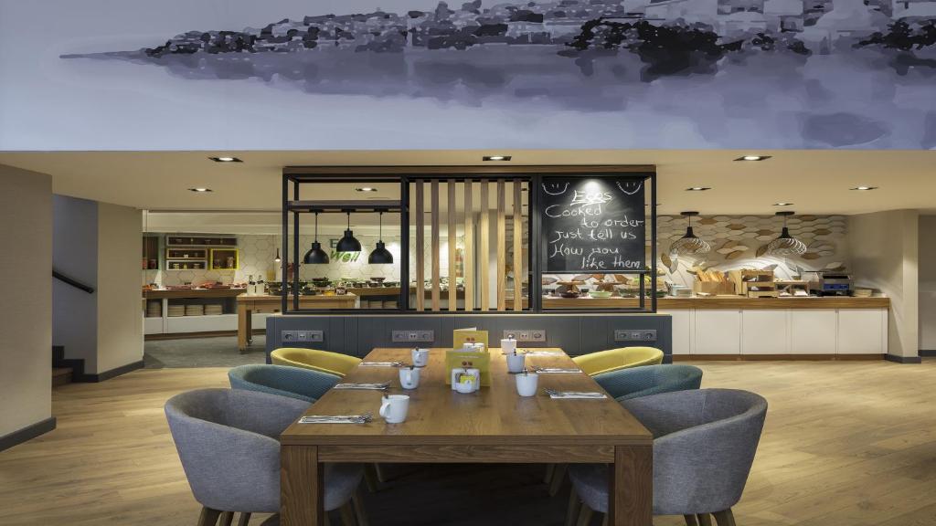a restaurant with a wooden table and blue chairs at Holiday Inn Istanbul Old City by IHG in Istanbul