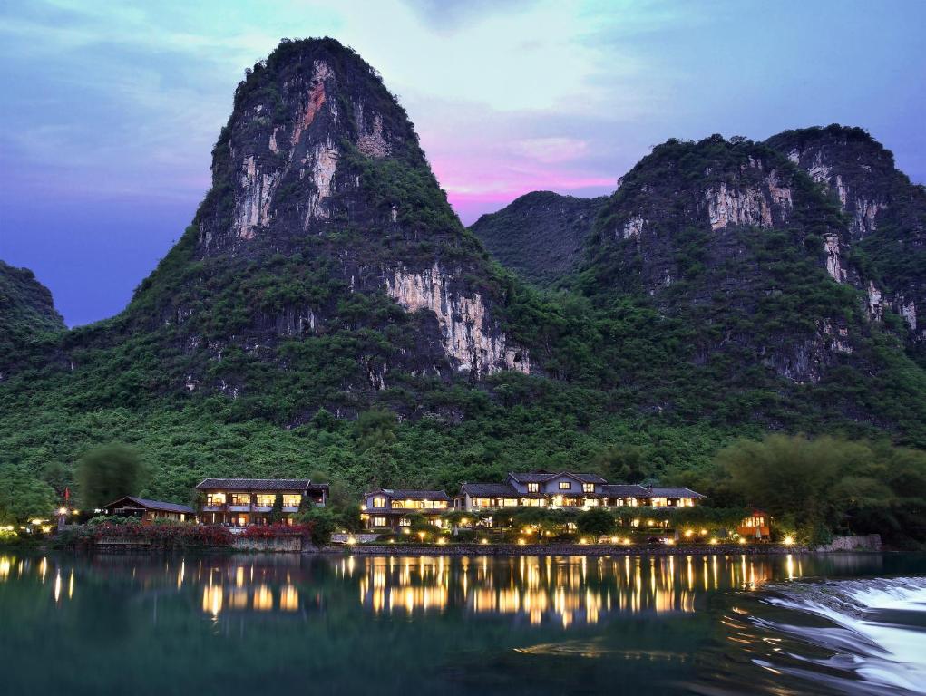 un complexe situé en face d'une montagne la nuit dans l'établissement Yangshuo Mountain Retreat, à Yangshuo