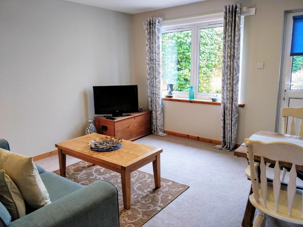 a living room with a couch and a tv and a table at Holiday Accommodation Perth Scotland - Oakview in Perth