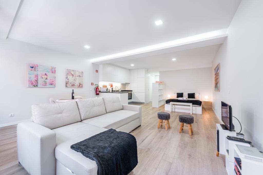 a white living room with a white couch and a table at Oporto Downtown View Apartment in Porto
