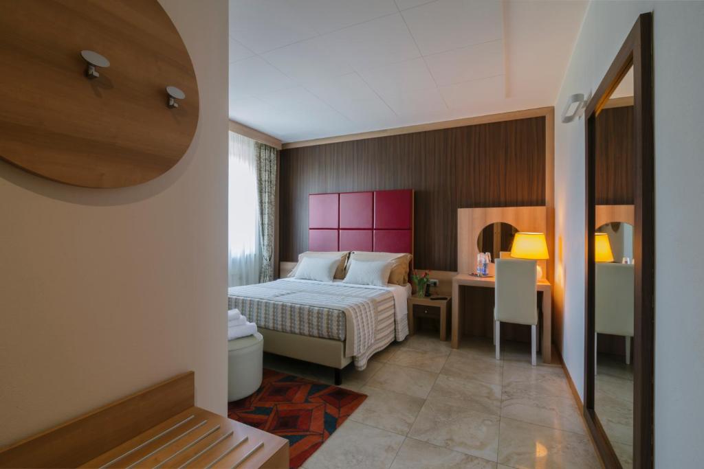 sypialnia z łóżkiem i biurkiem w pokoju w obiekcie Piccolo Hotel w mieście Palosco