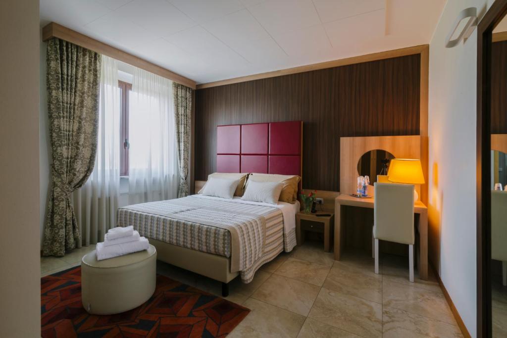 sypialnia z łóżkiem i biurkiem z krzesłem w obiekcie Piccolo Hotel w mieście Palosco