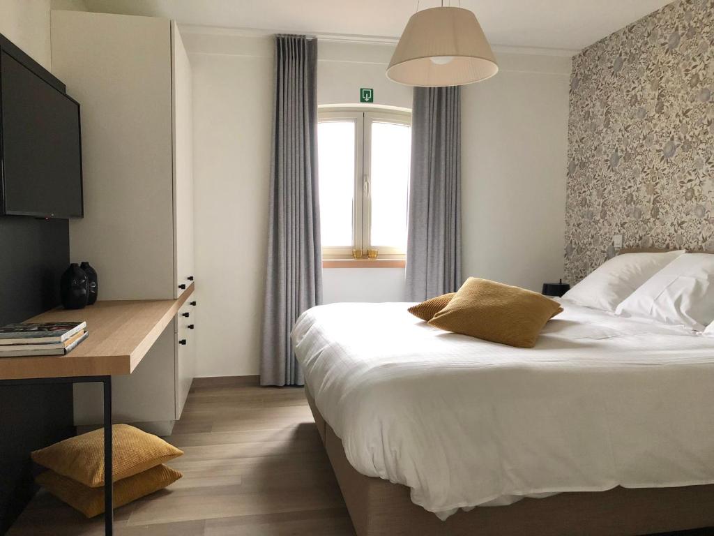 een slaapkamer met een bed, een bureau en een raam bij Elvier B&B in Mol