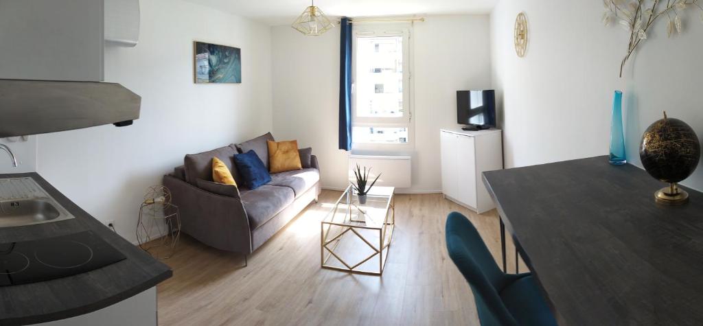 een woonkamer met een bank en een tafel bij "Monplaisir", beau studio neuf, classement 2 étoiles in Lyon