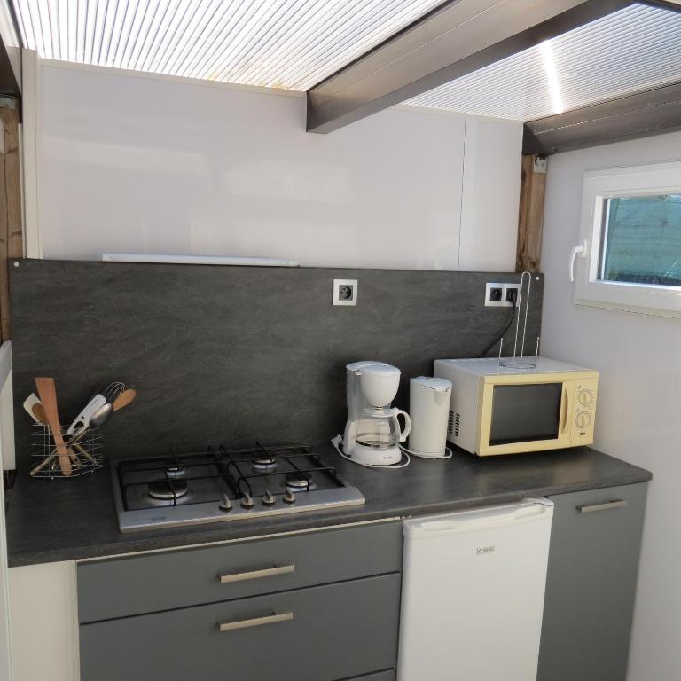 a kitchen with a stove and a microwave at La Picholine in Sorède