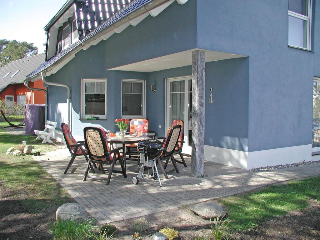 a patio with a table and chairs in front of a house at Ferienhaus Morgenstern F403 mit Kamin und Garten in Baabe