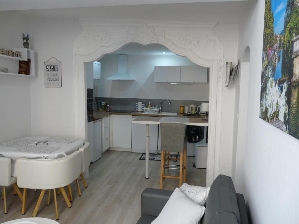 a living room and kitchen with a couch and a table at FLOTS DE L ISLE in LʼIsle-sur-la-Sorgue