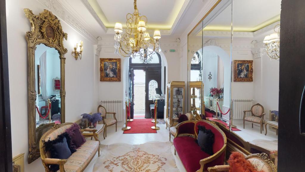 Elle comprend un salon doté d'un mobilier et d'un lustre. dans l'établissement Conacul Coroanei Luxury Boutique Hotel, à Bucarest