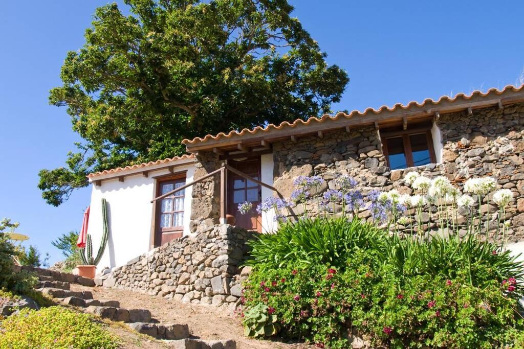 a stone house with a stone wall at Cozy stone house in the mountains in Arbejales