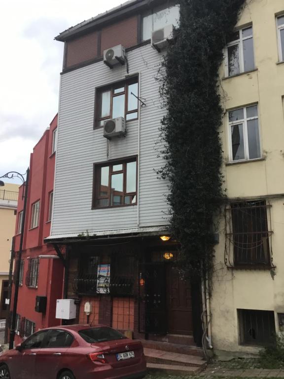 Un coche rojo aparcado delante de un edificio en Divan Wooden Guesthouse, en Estambul