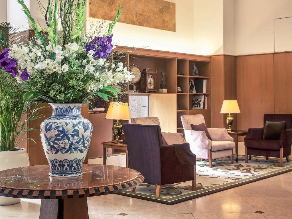 um vaso de flores numa mesa num quarto em The Cypress Mercure Hotel Nagoya em Nagoia