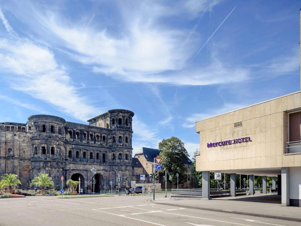 ein großes Steingebäude mit einer Straße davor in der Unterkunft Mercure Hotel Trier Porta Nigra in Trier