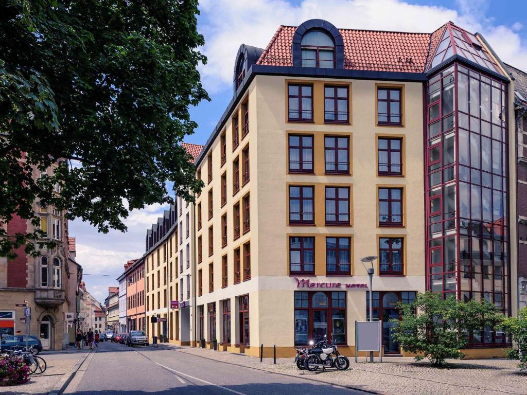 un edificio alto con techo rojo en una calle en Mercure Hotel Erfurt Altstadt, en Erfurt