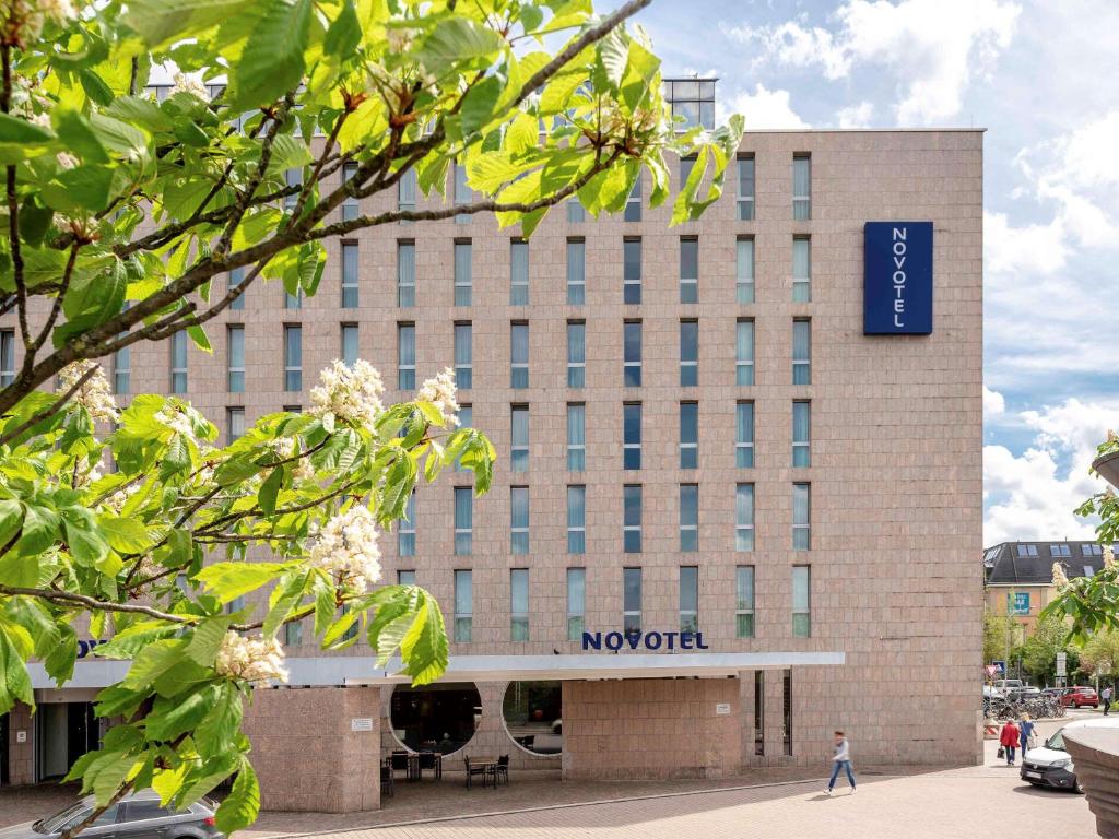 un bâtiment avec un panneau à l'avant dans l'établissement Novotel Freiburg am Konzerthaus, à Fribourg-en-Brisgau