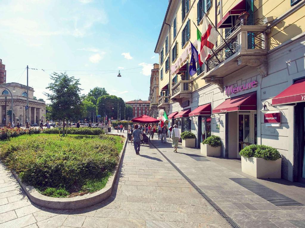 a street in a city with people walking on the sidewalk at Hotel Mercure Milano Centro in Milan