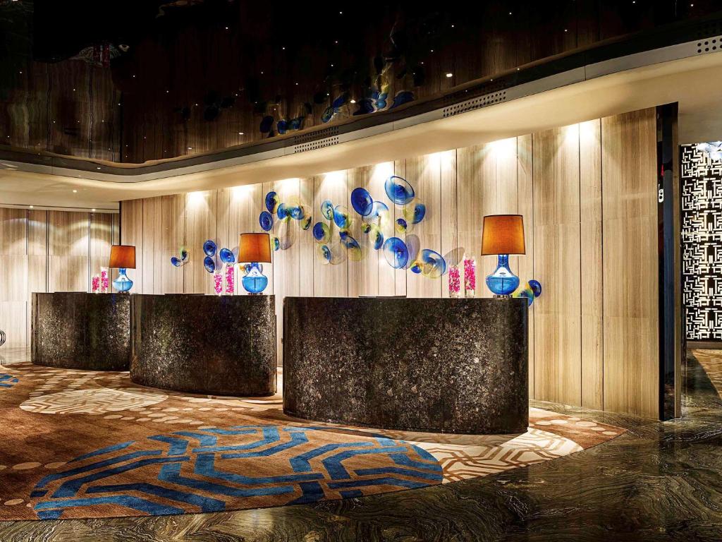 南京市にあるソフィテル 南京 ギャラクシーの青と白の花瓶が壁に飾られたロビー