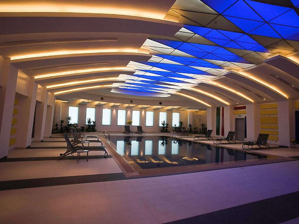 利雅德的住宿－利雅得奧諾德諾沃特酒店，中间设有游泳池的大型建筑
