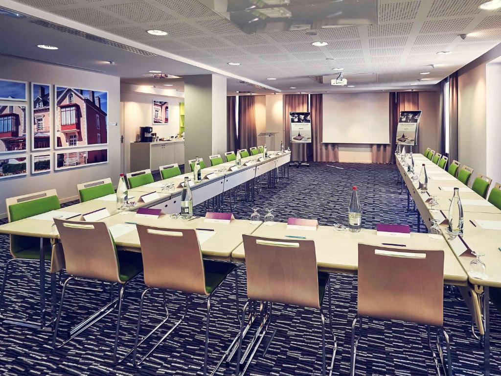 a conference room with a long table and chairs at Mercure Granville Le Grand Large in Granville