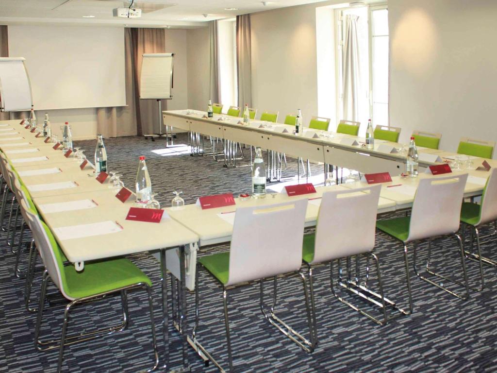 a conference room with rows of tables and chairs at Mercure Granville Le Grand Large in Granville