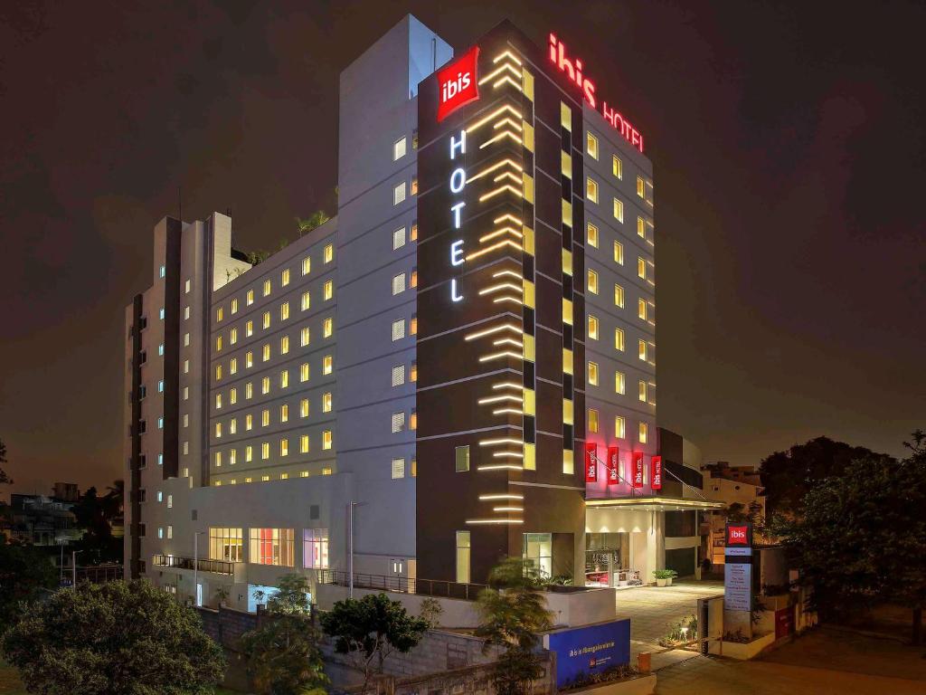 - un bâtiment éclairé avec un panneau d'hôtel dans l'établissement ibis Bengaluru City Centre - An Accor Brand, à Bangalore