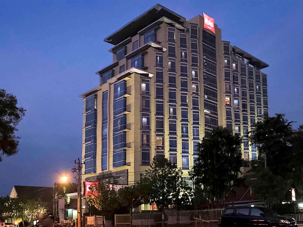 Hotel Ibis Semarang Simpang Lima في سيمارانغ: مبنى طويل مع علامة على الجانب منه