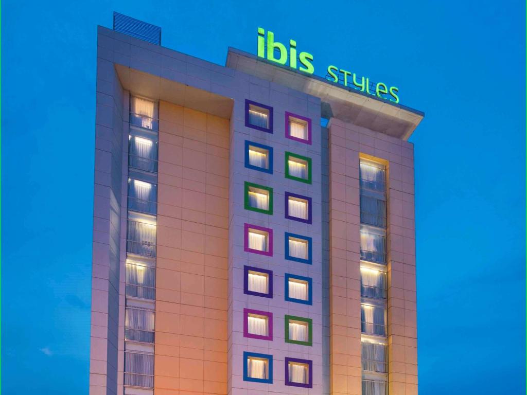 un bâtiment d'hôtel avec un panneau en haut dans l'établissement Ibis Styles Solo, à Solo