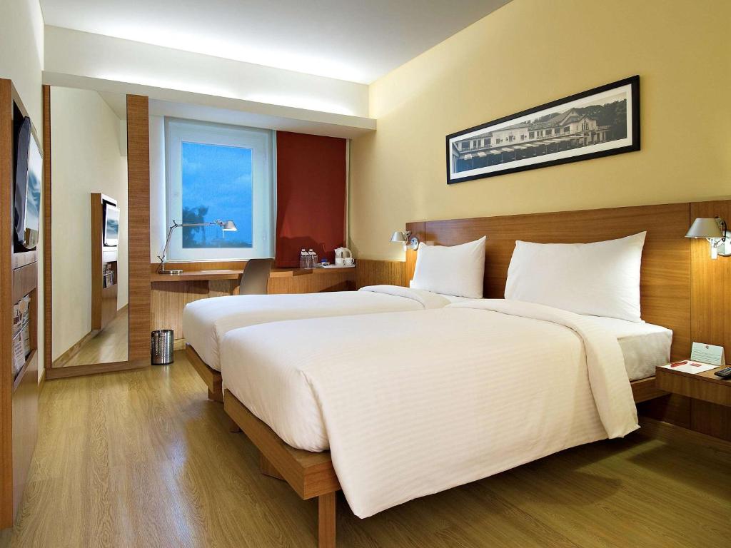 a bedroom with a large white bed and a window at ibis Pune Viman Nagar - An Accor Brand in Pune